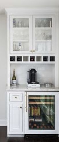 a kitchen with white cabinets and marble counter tops, along with dark wood flooring