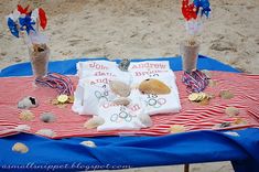 two vases filled with flowers on top of a red white and blue blanket