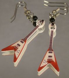 two red and white guitars are hanging from silver earwires with black bead hooks