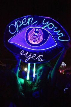 an open your eyes sign lit up at night