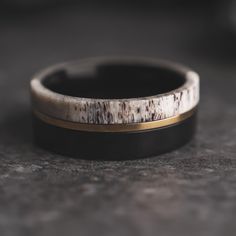 a black and white wedding band with gold inlays on the inside of it