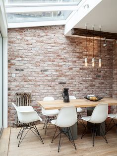 a dining room with brick walls and white chairs