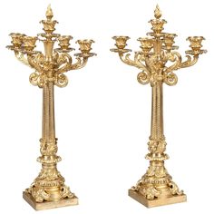 two golden candelabras with candlesticks on them