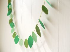 green paper leaves are hanging from a string