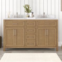 a bathroom vanity with two sinks and a rug on the floor in front of it