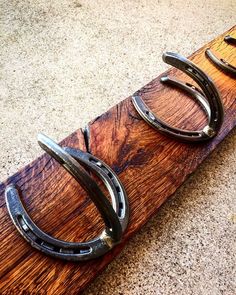 two pairs of scissors sitting on top of a wooden board with metal rings attached to it