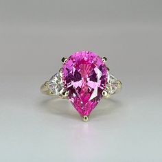 "The ring pictured is a pear lab created pink sapphire  #6519 This ring is  offered with either Charles and Colvard Moissanite or Zonar Moissanite accents Use the drop down menu to make your selection. Zonar Moissanite by Infinity is our own hand cut moissanite near colorless stone.   All of our moissanite stones come with a limited lifetime warranty and an authenticity card is included. Moissanite may take up to 5 to 10 business days to complete and ship, sometimes sooner. -Approximate total ca Engagement Ring Pink, Pink Sapphire Engagement Ring, Floral Wedding Bands, Pink Engagement Ring, Pink Sapphire Ring Engagement, Charles And Colvard Moissanite, Moissanite Engagement Ring Oval, Ladies Ring, Sapphire Engagement Ring