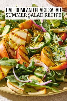 a salad with peaches, spinach and other vegetables on a yellow plate next to a wooden bowl