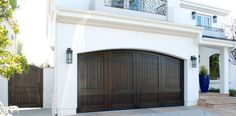 a large white house with two brown garage doors