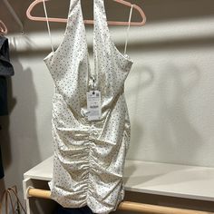 a white polka dot top hanging on a clothes rack