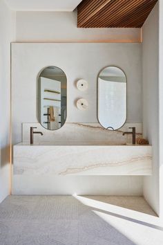 a bathroom with two sinks and mirrors on the wall