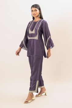 Dusty purple short kurta with pleated cuffs, highlighted with floral embroidered bodice. Paired with a pant with floral embroidered lace.
Components: 2
Pattern: Embroidery
Type Of Work: Floral
Neckline: Round Neck
Sleeve Type: Full Sleeves
Fabric: Kurta and Pant: Bamber silk, Lining: Mul cotton
Color: Purple
Other Details: 
Attached inner lining
Closure: Elastic
Occasion: Puja - Aza Fashions Purple Straight Kurta Set For Diwali, Purple Chanderi Sets With Resham Embroidery, Purple Zari Work Blouse For Eid, Purple Palazzo Set Shaped Like Saree For Eid, Purple Sets With Resham Embroidery For Transitional Season, Designer Purple Palazzo Set With Chikankari Embroidery, Purple Blouse Piece With Chikankari Embroidery For Eid, Purple Chikankari Embroidered Blouse Piece For Eid, Purple Silk Sets With Chikankari Embroidery