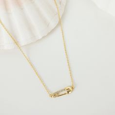 This is a fine chain necklace, made from 18 karat gold-plated sterling silver, that has a small safety pin pendant embellished with tiny zirconia integrated into the center front of it, a round spring clasp at the center back, and a short extension chain for an adjustable fit. A delicate and timeless piece that will complement anything from fine knits to silk blouses to denim wear.  🎁 Packaging: Beautifully packed in a box, ready for gifting. Details: ✅ Material: 925 sterling silver with 18k gold plated, cubic zirconia ✅ Length: 42.0 cm (16.53 inches) + 5.0 cm (1.96 inches) extension ✅ Pendant Size: 17.5 mm * 6.0 mm (0.68 * 0.23 inches) ✅ Weight: 6.0 g (0.21 oz) 🏷️ This product is made of sterling silver -- easily recognizable by its '925' stamp of authenticity. It is also hypoallergenic Vivienne Westwood Safety Pin Necklace, Minimalist Gold Safety Pin Earrings, Gold Safety Pin Shaped Jewelry With Charms, Cheap Gold Safety Pin, Gold Safety Pin Shaped Brooch, Daisy Pendant, Pin Pendant, Safety Pin, Gold Pendant Necklace