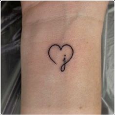 a small heart tattoo on the wrist