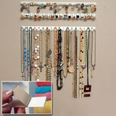 a wall mounted jewelry rack with several different types of necklaces and bracelets hanging on it