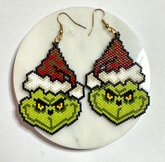 the grin face earrings are made out of plastic bead and have santa hats on them