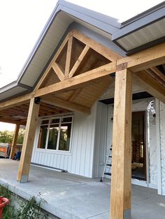 the front porch of a house with wood beams