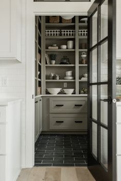 an open door leading into a kitchen with white cabinets