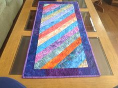 a table with a colorful quilt on it