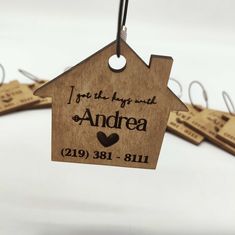 personalized wooden house ornament hanging on clothes pins with name tags attached to it