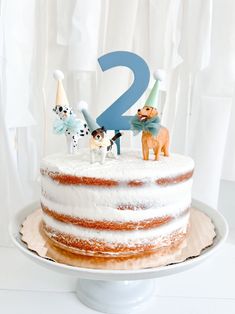 a white cake with frosting and two dogs on top