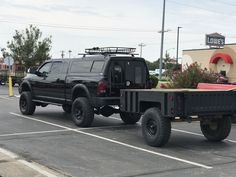 a black truck with flowers in the bed is parked in a parking lot next to a motel