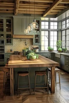 a large kitchen with wooden floors and green cabinetry, along with two stools at the island