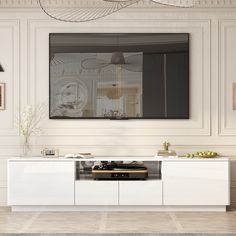 a white entertainment center with a large mirror on it's wall above the television