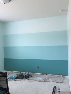 an empty room with blue and green paint on the walls