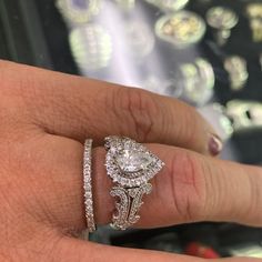 a woman's hand with two rings on it and an engagement ring in the middle