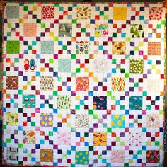 a colorful quilt is hanging on the wall