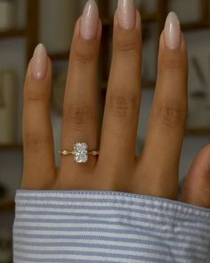 a woman's hand with a diamond ring on it