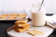 there are crackers and a glass of milk on the table