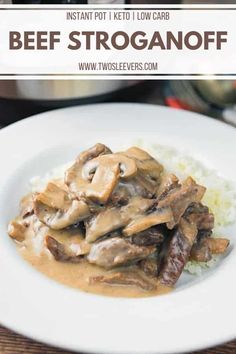 a white plate topped with beef and mushrooms covered in gravy on top of rice