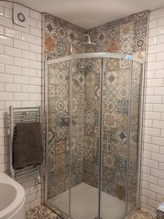 a corner shower stall in a tiled bathroom