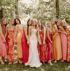 a group of women standing next to each other in dresses