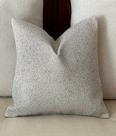 a white pillow sitting on top of a couch