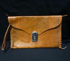 Here is a beautiful leather handbag , clutch bag,  leather wristlet, this beautiful vintage bag has saddle stitching at the sides a great Embossed pattern flowers and leafs on the front and back also a lovely sliver clasp which works.   A great vintage piece for All you great vintage lovers.  Measurements :   Approximately  Length :  9 - 3/4  Inches  Measured near the bottom.  Height :  6 - Inches  Condition : Good Vintage Condition  Some scratches all over this bag, sliver coloured metal clasp Vintage Handheld Clutch For Everyday Use, Vintage Satchel Clutch For Everyday Use, Vintage Crossbody Clutch For Daily Use, Vintage Handheld Clutch For Daily Use, Vintage Pouch Clutch For Everyday Use, Vintage Everyday Crossbody Clutch, Vintage Crossbody Clutch For Travel, Vintage Leather Clutch For Everyday Use, Vintage Envelope Bag For Everyday Use