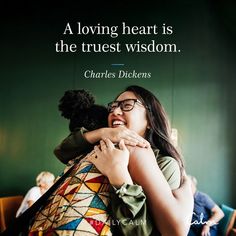 a woman hugging another woman with a quote on the wall behind her that reads, a loving heart is the trust wisdom charles dickens