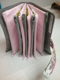 four pink and grey purses are lined up next to each other