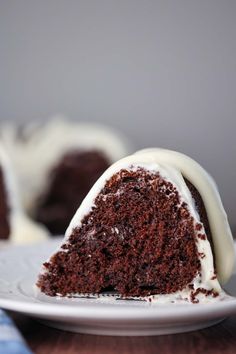 a slice of chocolate cake with white frosting on a plate