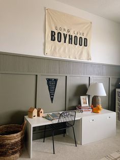 a room with a bed, desk and chair in it next to a wall banner