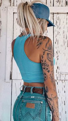 a woman with tattoos on her arms and back