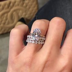 a woman's hand with two rings on it and a diamond ring in the middle