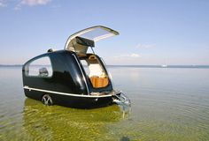 a small black boat floating on top of a lake filled with green algae covered water