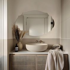 a bathroom with a sink, mirror and towel on the counter top in front of it