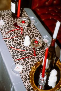 the table is set with wine and candles for an elegant dinner or special occasion in leopard print