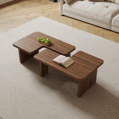 two wooden tables sitting on top of a rug in front of a couch and coffee table