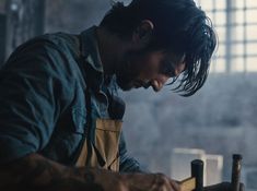 a man is working on something in a workshop with an old fashioned hammer and other tools