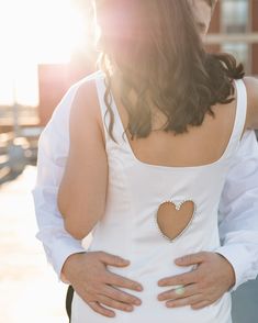 a man and woman standing next to each other with their hands on their stomachs